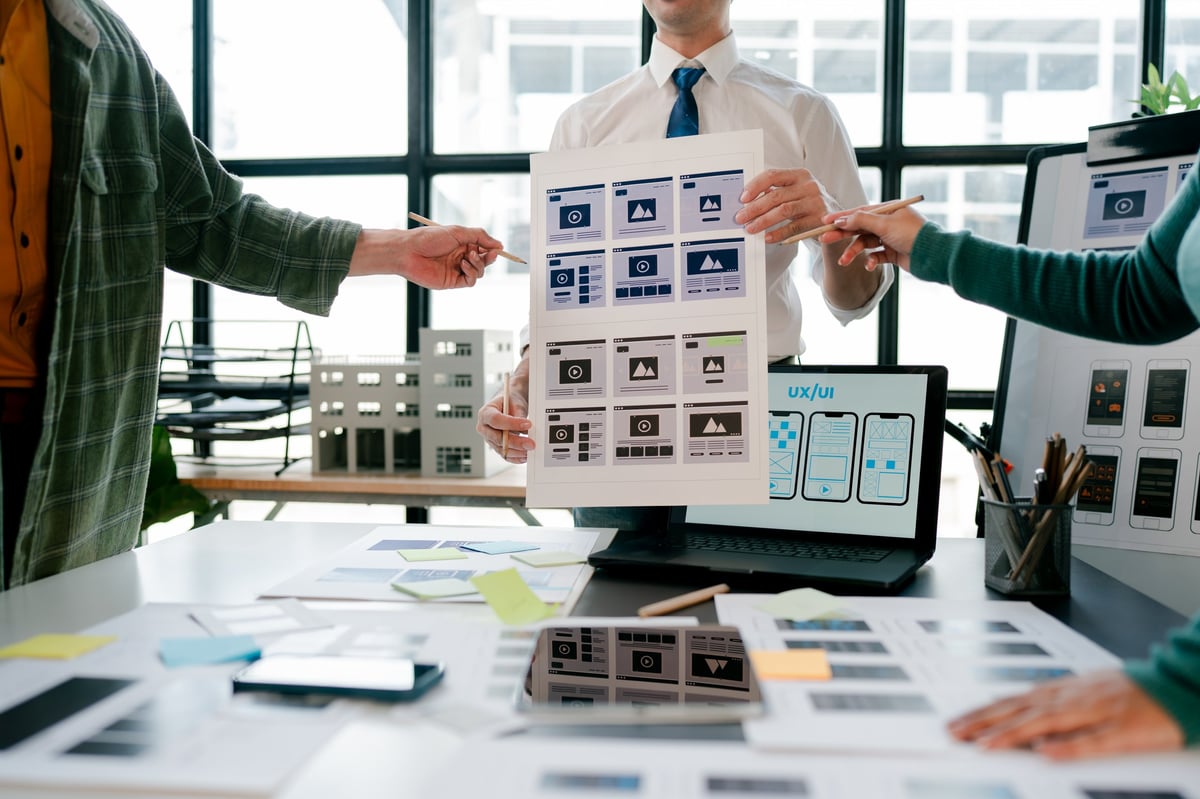 Designers reviewing wireframes for a local products website concept.